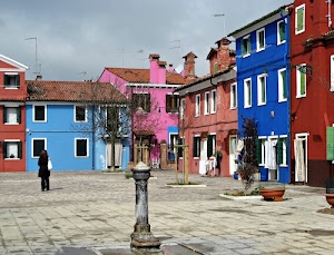 fontana, piazza, colori, case, finestre, alberi, rosa, azzurro, persona, blu, comignoli, donna, passante, porte, cielo, antenne, tetti, multicolore, fontanella, borgo, vasi, piazzetta